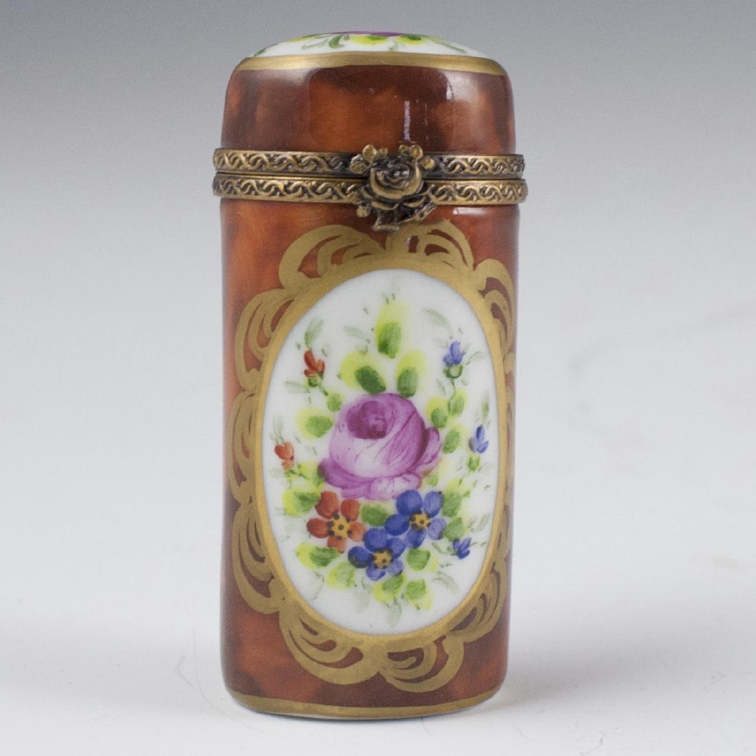 Parry & Vieille Limoges Porcelain Pill Box: DESCRIPTION: A Parry & Vieille Limoges Porcelain Pill Box. Features an oval form garnished with a rust base hue and centered by floral motifs. Finished with a gilt metal lining and a rose motif clasp.
