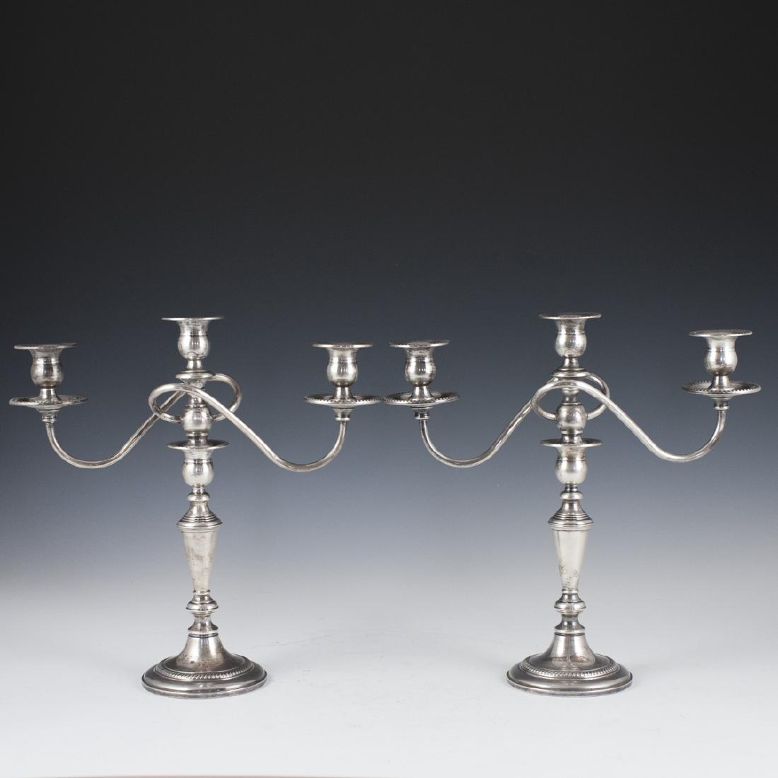 Fishter Weighted Sterling Candelabras: DESCRIPTION: A pair of Fisher sterling weighted candelabras. Features rotund bases embellished with embossed gadroon designs enveloping the tapering, spindled stem. The top of the stem is designed wit