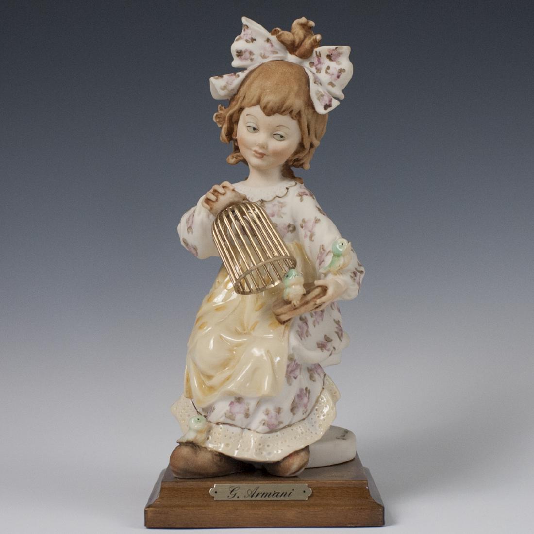 Giuseppe Armani Figurine: DESCRIPTION: A Giuseppe Armani resin figurine of a young girl playing with birds while seated atop a chair. Hand Painted with floral motifs along her clothing and finished with gloss glazes along her 