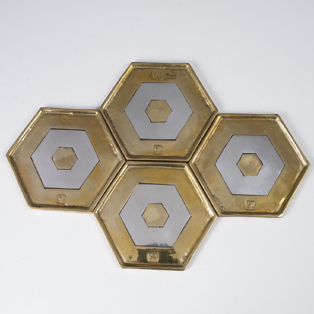 David Marshall "Marrakech" Bottle Mats: DESCRIPTION: A set of 4, David Marshall, mixed metal, "Marrakech" bottle mats. Features hexagonal forms with brass and aluminum layers. Marked with David Marshall stamps. CIRCA: Late 20th-Early 21st c