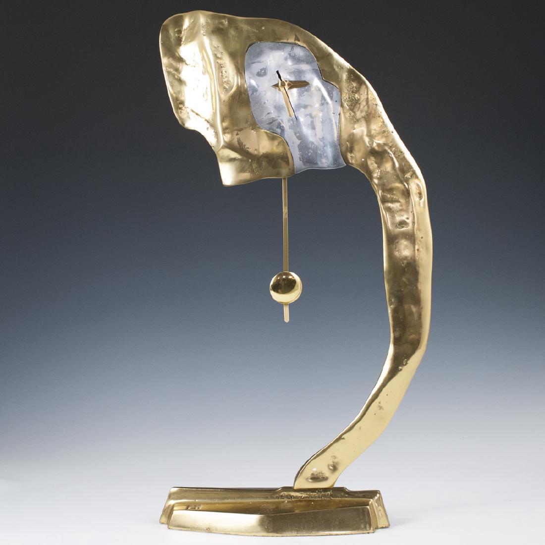 David Marshall "Alpes" Clock: DESCRIPTION: A David Marshall "Alpes" clock. Composed of a brass foundation with an aluminum face. Uses a battery operated movement and pendulum. Marked with David Marshall stamp. CIRCA: Late 20th-Ear