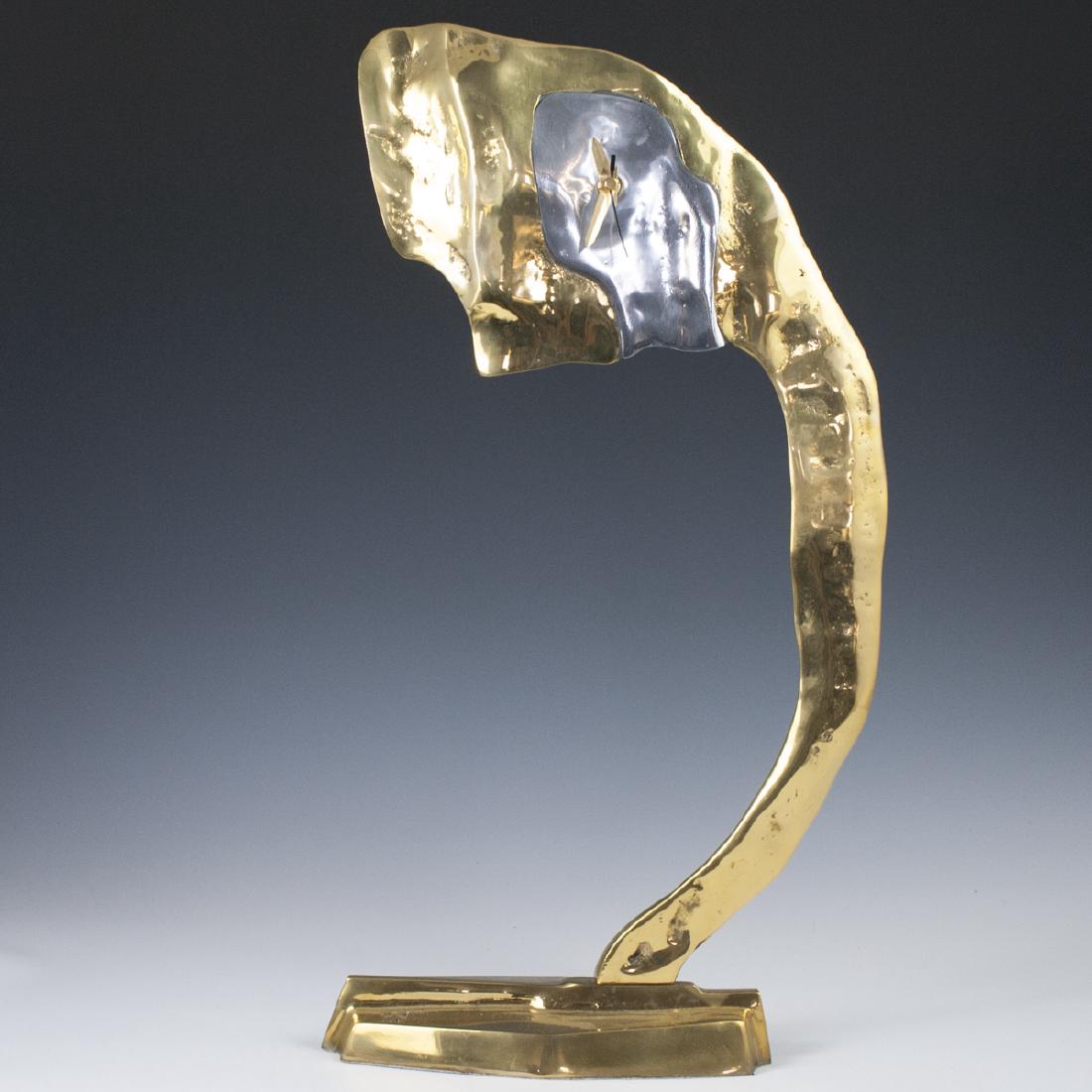 David Marshall "Alpes" Clock: DESCRIPTION: A David Marshall "Alpes" clock. Composed of a brass foundation with an aluminum face. Uses a battery operated movement and pendulum. Marked with David Marshall stamp. CIRCA: Late 20th-Ear