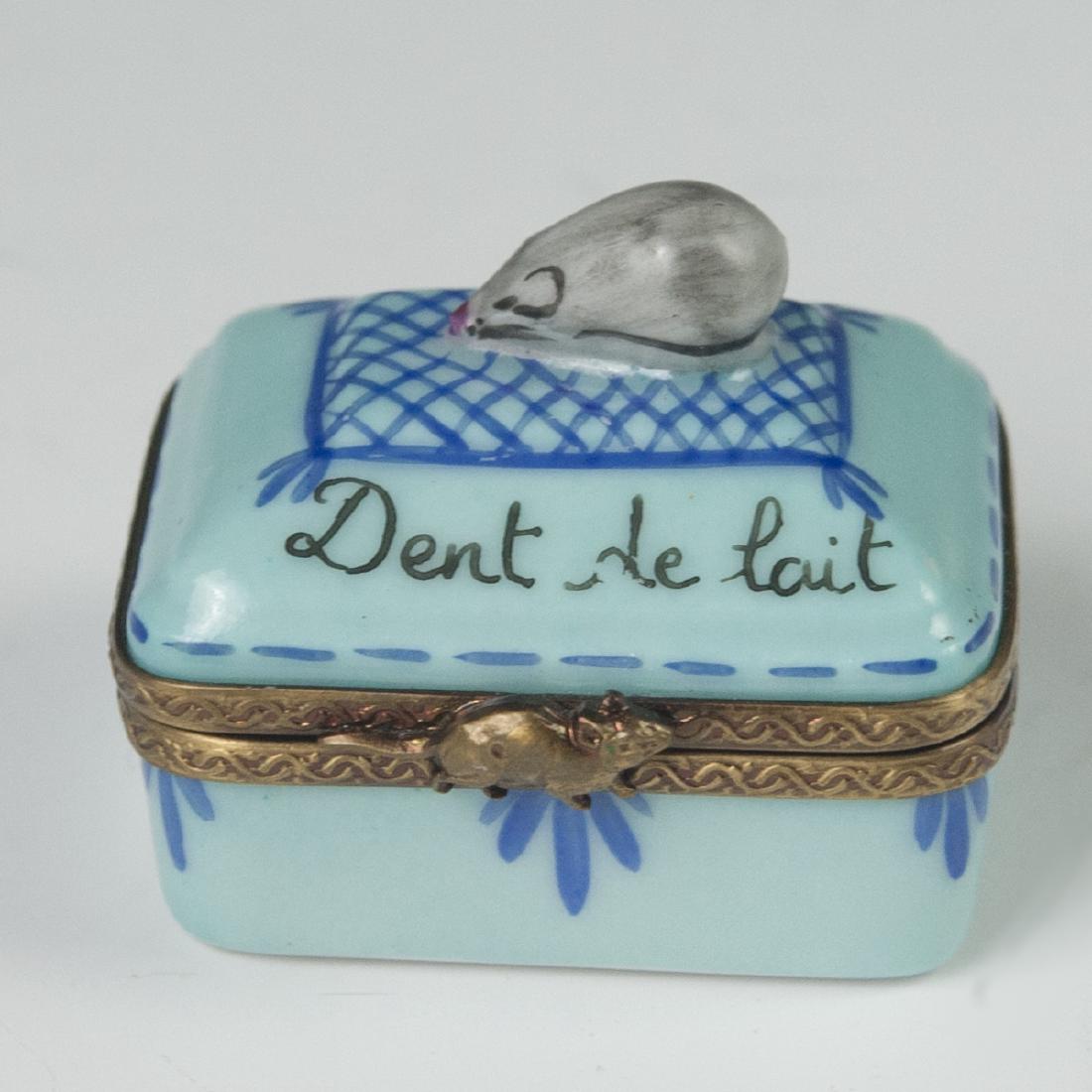 Limoges Porcelain Pill Box: DESCRIPTION: Limoges porcelain pill box. Features a mouse motif finial along the lid, and a gilt metal lining and a mouse motif clasp. Marked:"Dent de Lait" as well as:"Limoges France Peint Main". CIR