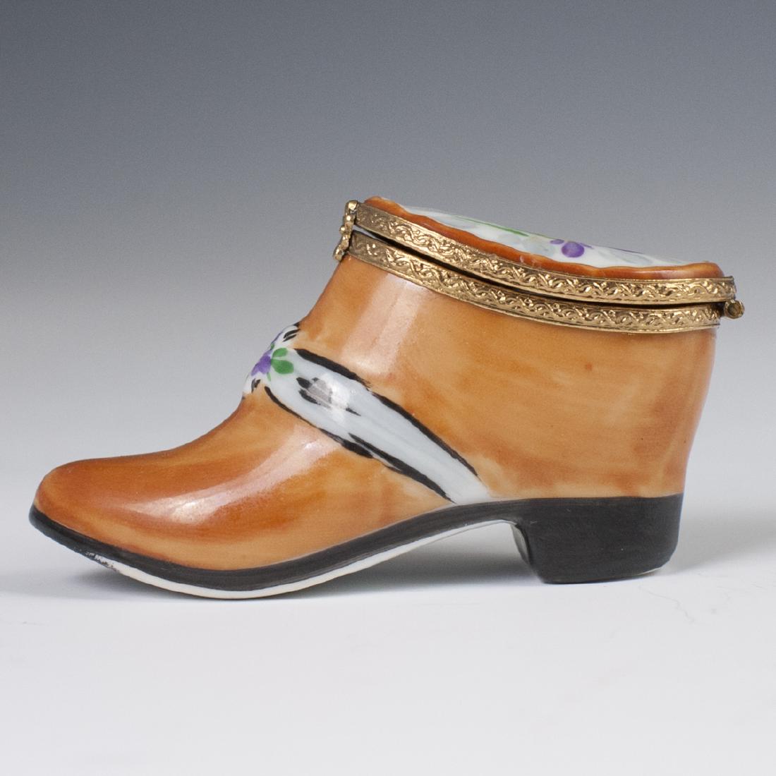 Limoges Porcelain Pill Box: DESCRIPTION: A Limoges porcelain pill box in the motif of a lady's boot. Finished with a gilt metal lining and a rosette motif clasp. Marked:"Peint Main Limoges France". CIRCA: Mid-Late 20th Ct. ORIGI
