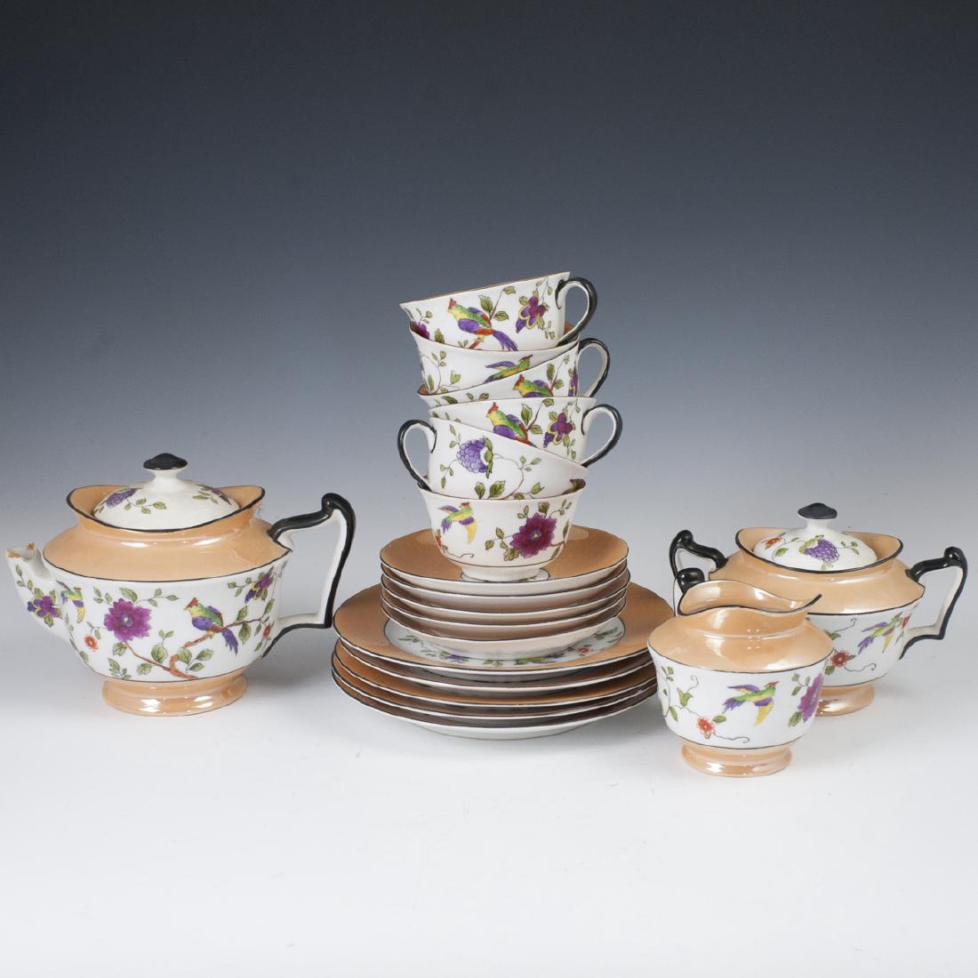 Noritake Porcelain Set: DESCRIPTION: A Noritake porcelain set. Embellished with grape clusters, floral and pheasant motifs, embellished with iridescent, gilded hues. Marked: "Noritake Handpainted Made in Japan". Composed of 