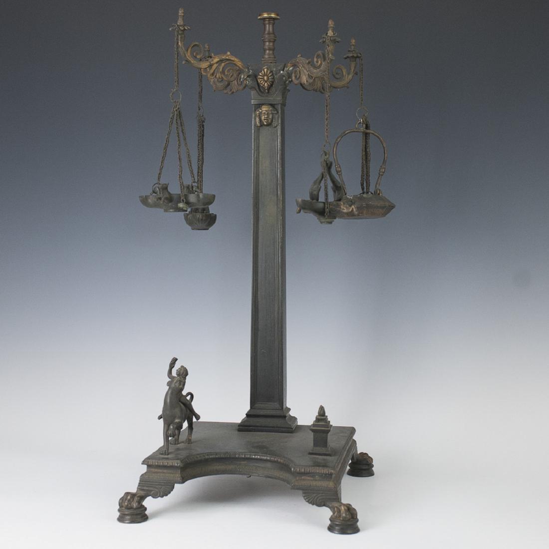 Antique Neoclassical Bronze Roman Oil Lamp: DESCRIPTION: An antique Neoclassical bronze oil lamp in an overall Bacchanal Roman, motif. Features lion paw motif feet supporting the base, embellished with a nude figure, weilding a wine chalice whi