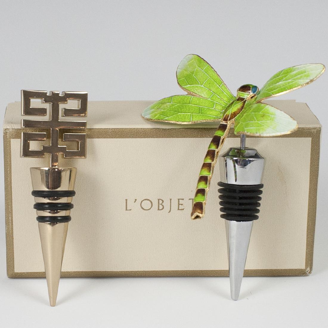 Wine Bottle Stoppers: DESCRIPTION: A set of two wine bottle stoppers. The first is from L'Objet, and features a gilded logo finial and includes original box. The other is an enamel stopper with an enameled dragonfly. CIRCA