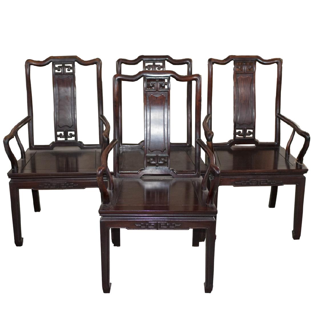 Carved Chinese Wooden Arm Chairs: DESCRIPTION: A set of four Chinese carved wooden arm chairs. Composed of an overall carved wooden foundation designed with two arching back legs and two straightened front legs, intersected by carved 
