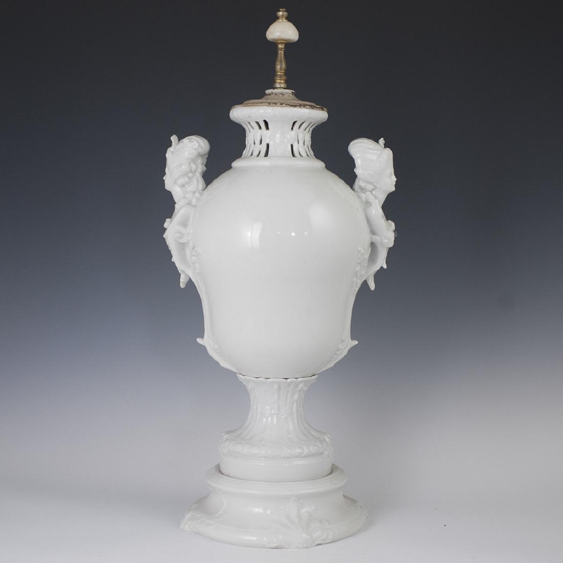 Saxon Porcelain Manufactory Dresden Urn: DESCRIPTION: A Saxon Porcelain Manufactory Dresden urn. Features a tapering base garnished with embossed Rococo shell motifs, centered by the bottom of the urn, garnished with embossed scrolled Rococo
