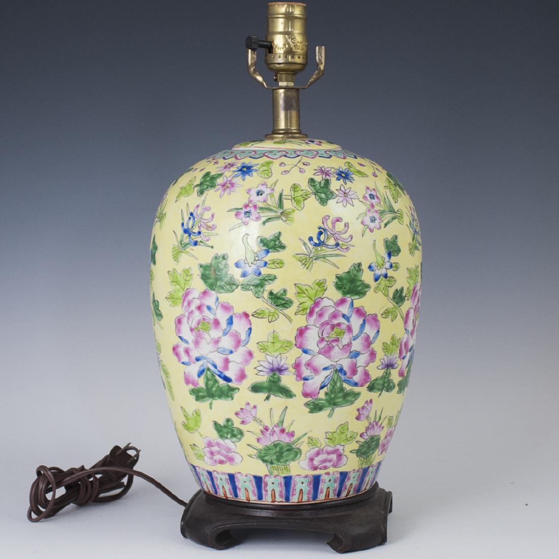 Chinese Porcelain Famille Jaune Lamp: DESCRIPTION: A Chinese porcelain lamp composed of a converted ginger jar, embellished with a yellow base hue and embellished with enameled floral motifs throughout. Fitted to a footed wooden base and 