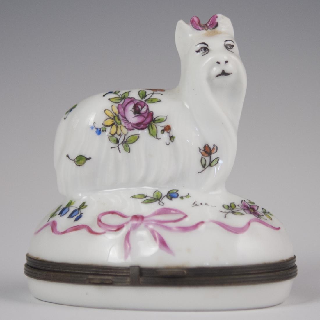 Limoges Paris-Style Porcelain Pill Box: DESCRIPTION: A Limoges Paris-Style, porcelain pill box. Features an oval form, embellished with tied ribbons and centered by a standing Yorkshire terrier figurine. Marked along the underside:"Porcelai