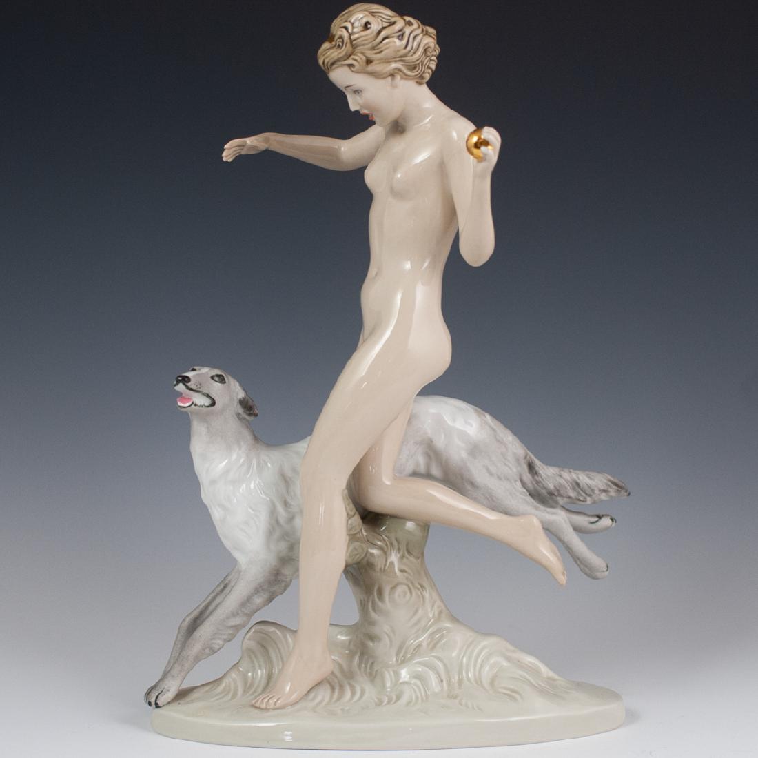 Vintage Royal Dux Porcelain Figurine: DESCRIPTION: A vintage Royal Dux, large porcelain figurine of a nude woman throwing a gilded ball, as a dog runs beside her. Finished in an overall gloss glaze and marked along the underside with Roya