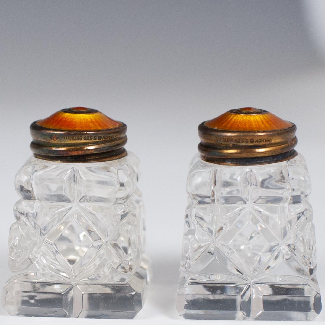 Norwegian Enameled Sterling Crystal Cellars: DESCRIPTION: A pair of Norwegian salt and pepper shakers composed of cut crystal bodies, garnished with sterling guilloche enameled lid in an amber tone. Marked:"Serling 925 S Norway". CIRCA: Mid 20th