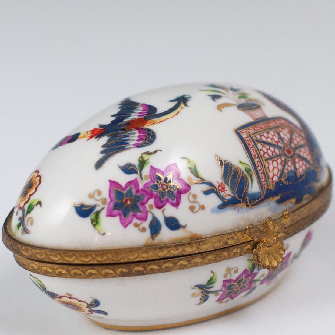 Le Tallec Chionoiserie Porcelain Pill Box: DESCRIPTION: A Le Tallec porcelain pill box. Features an ovoid form, garnished with handpainted Chinoiserie motifs of a fenghuang and soaring insects amongst floral motifs. Finished with a gilt brone 