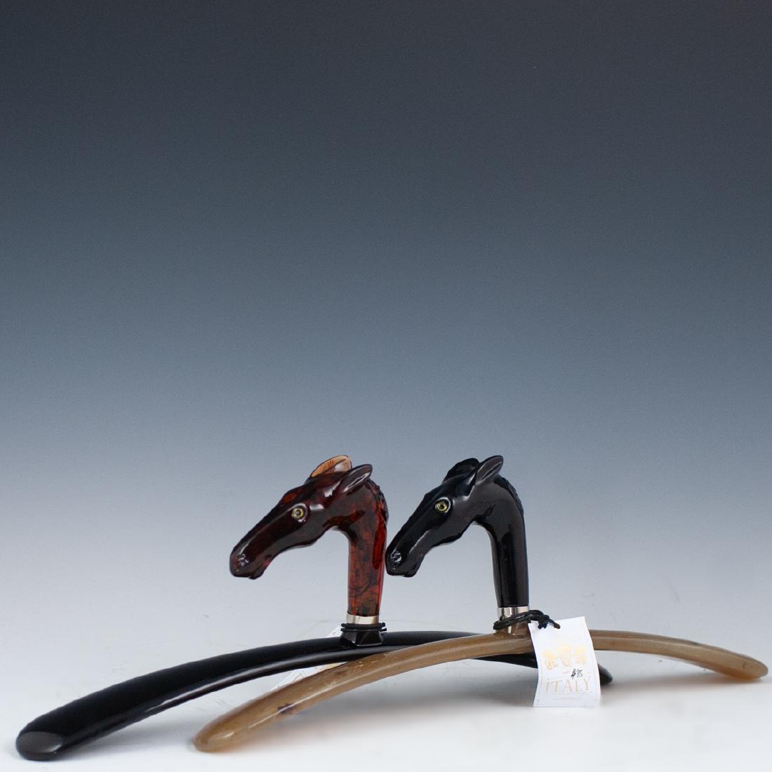 Vintage Italian Bakelite Coat Hangers: DESCRIPTION: A pair of vintage Italian, bakelite coat hangers composed of a horse head centering the sloped foundation. Tagged:"Created in Italy". CIRCA: Mid-Late 20th Ct. ORIGIN: Italy DIMENSIONS: H:
