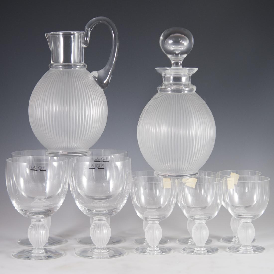 Lalique Crystal "Langeais" Stemware: DESCRIPTION: A Lalique crystal "Langeais" patterned stemware set. Includes: 4 large water glasses, 6 burgundy red wine glasses, a water pitcher, and a decanter. Each are decorated with bulbous, ridged