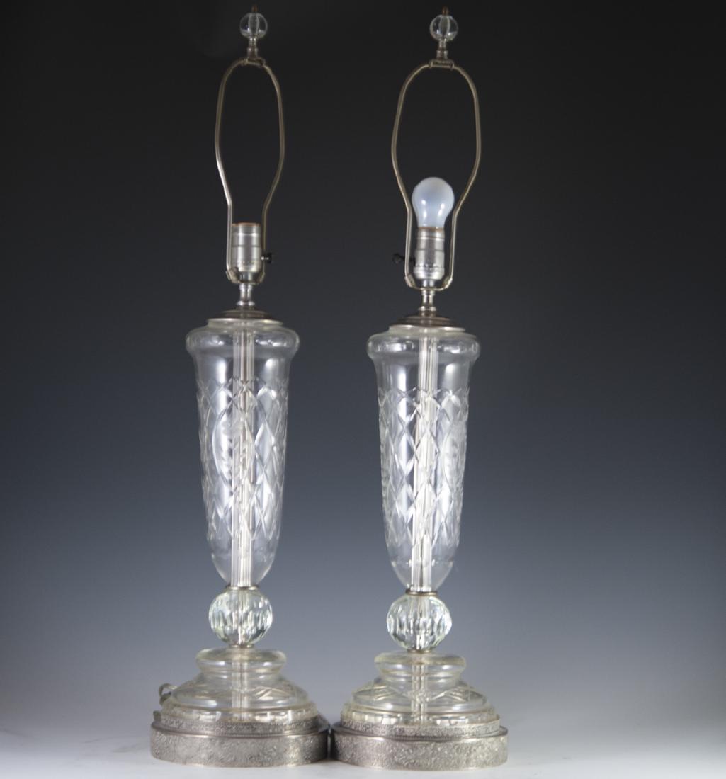 Silverplated & Crystal Lamps: DESCRIPTION: A pair of lamps featuring silverplated bases with embossed floral rococo scrolled motif. Resting on the silverplated bases is the cut crystal bases and stem decorated with etched floral m