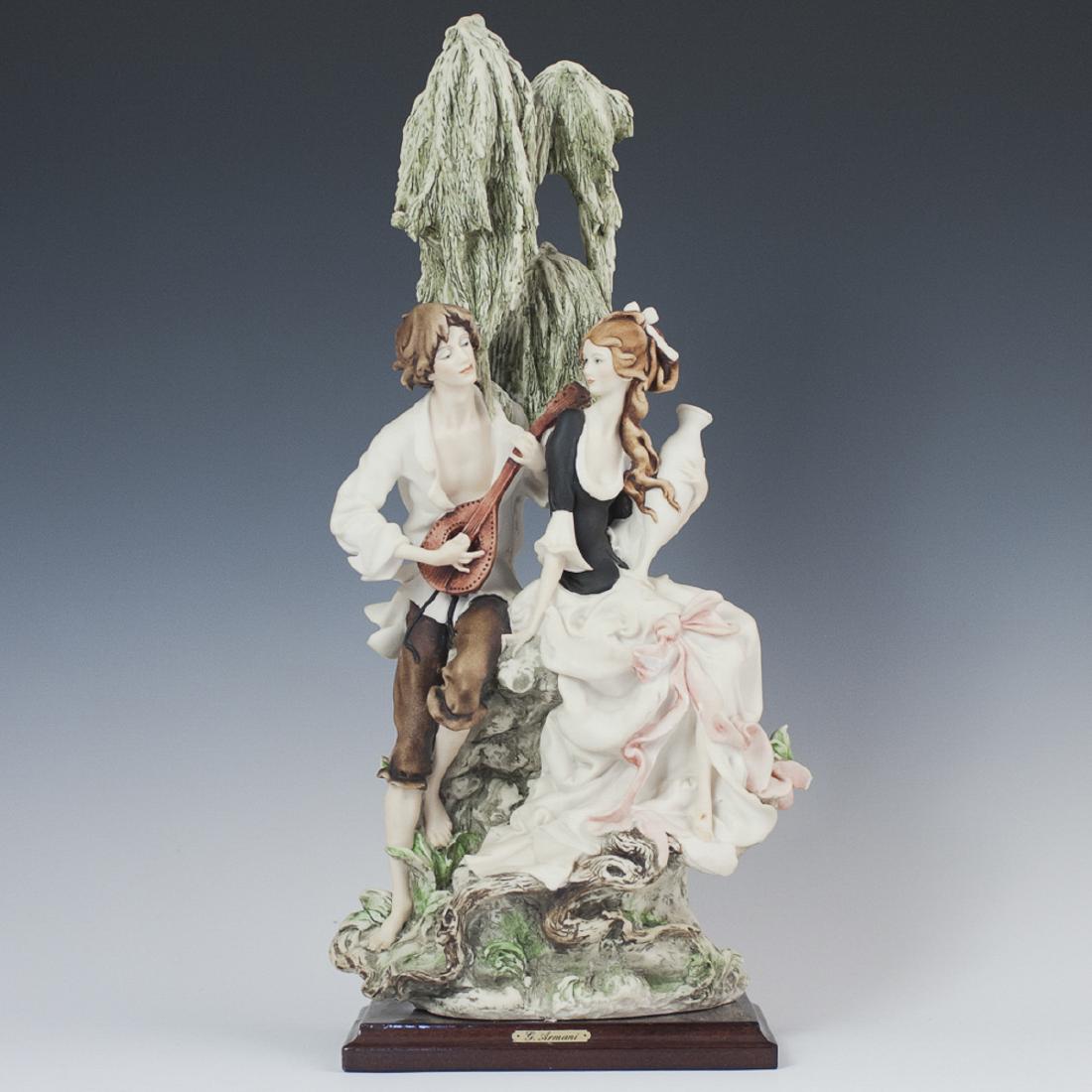 Giuseppe Armani Resin Sculpture: DESCRIPTION: A Giuseppe Armani resin sculpture of a man wielding a stringed instrument, courting a woman wielding a vase under the canopy of a tree, Fitted to a wooden base. Marked along verso: "Flore