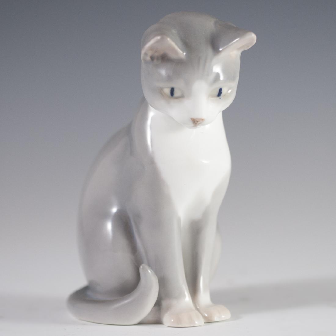 Bing & Grondahl Porcelain Cat Figurine: DESCRIPTION: A Bing & Grondahl porcelain figurine of a cat with its head peering downwards. Finished with a glossed glaze and marked with Bing & GrÃƒÂ¸ndahl marks on the bottom. CIRCA: 20th Ct. OR