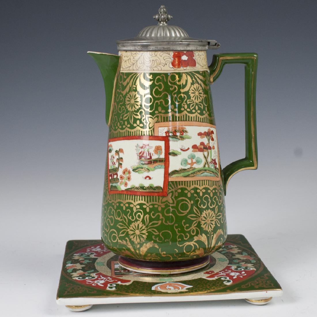 Masons Ashworth Chinoiserie Porcelain Set: DESCRIPTION: A Masons Ashworth, Chinoiserie motif porcelain set composed of a hot water pot with a pewter lid, and a bottom tray. Embellished Chinoiserie motifs of palanquin structures amongst bridges