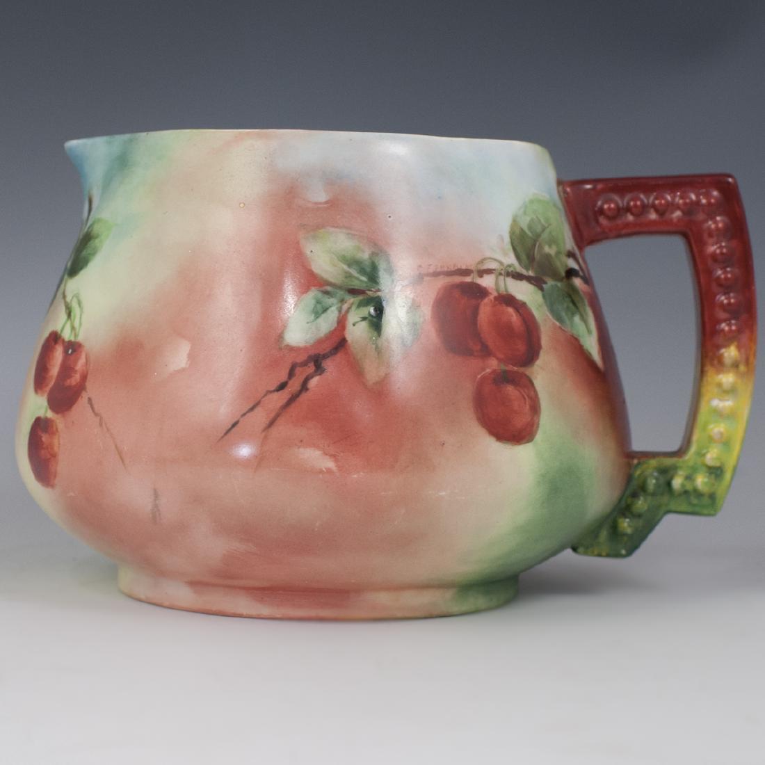 Jean Pouyat Limoges Porcelain Pitcher: DESCRIPTION: A Jean Pouyat Limoges porcelain pitcher. Features a rotund form embellished with a cherry on branch motif. Marked along the underside:"JP Limoges". CIRCA: Early 20th Ct. ORIGIN: France DI