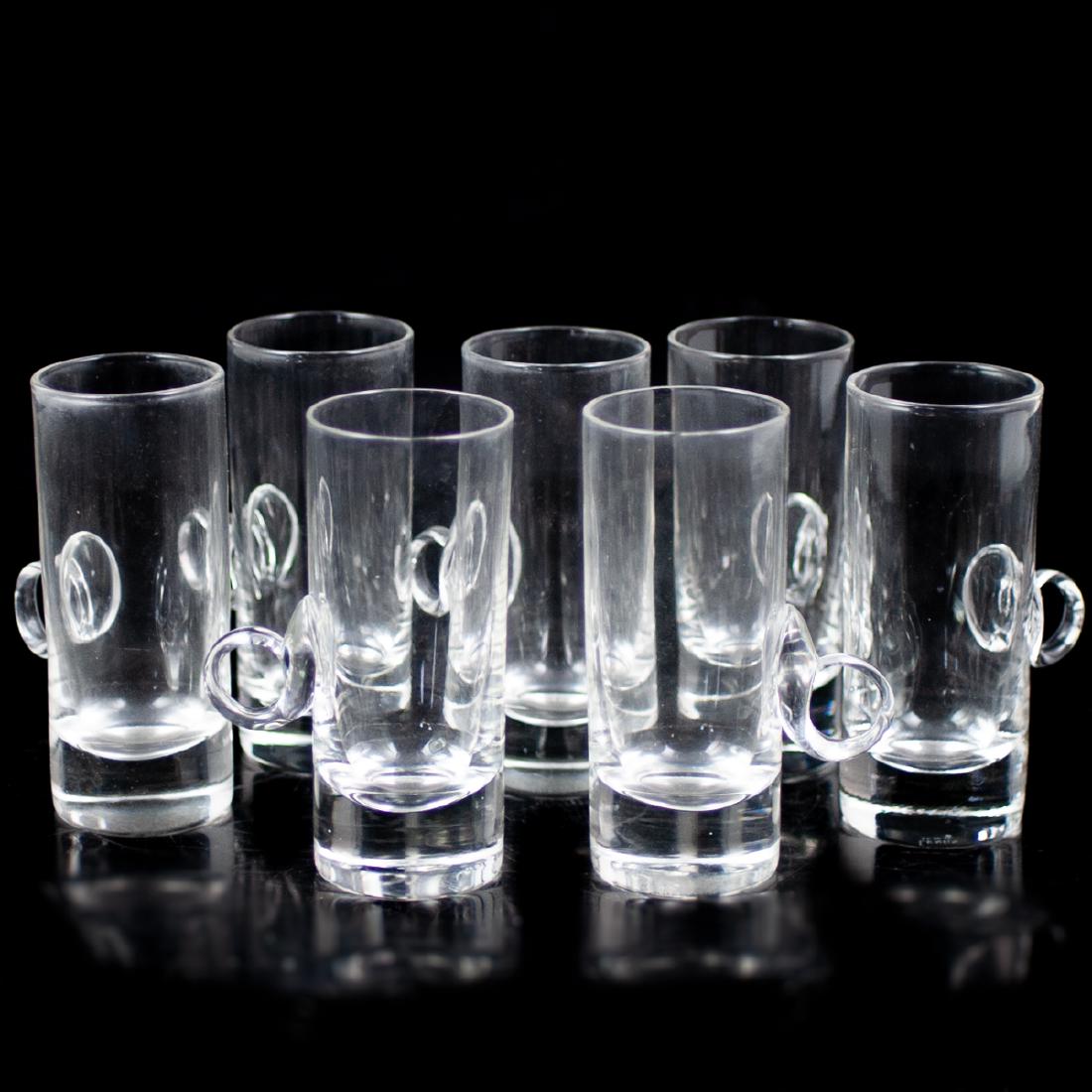 Lenox Crystal Liquor Glasses: DESCRIPTION: A set of 7 Lenox crystal liquor glasses. Features slender, cylindrical forms embellished with arching handles. Marked:"Lenox" along the undersides. CIRCA: Mid-Late 20th Ct. ORIGIN: Uncert