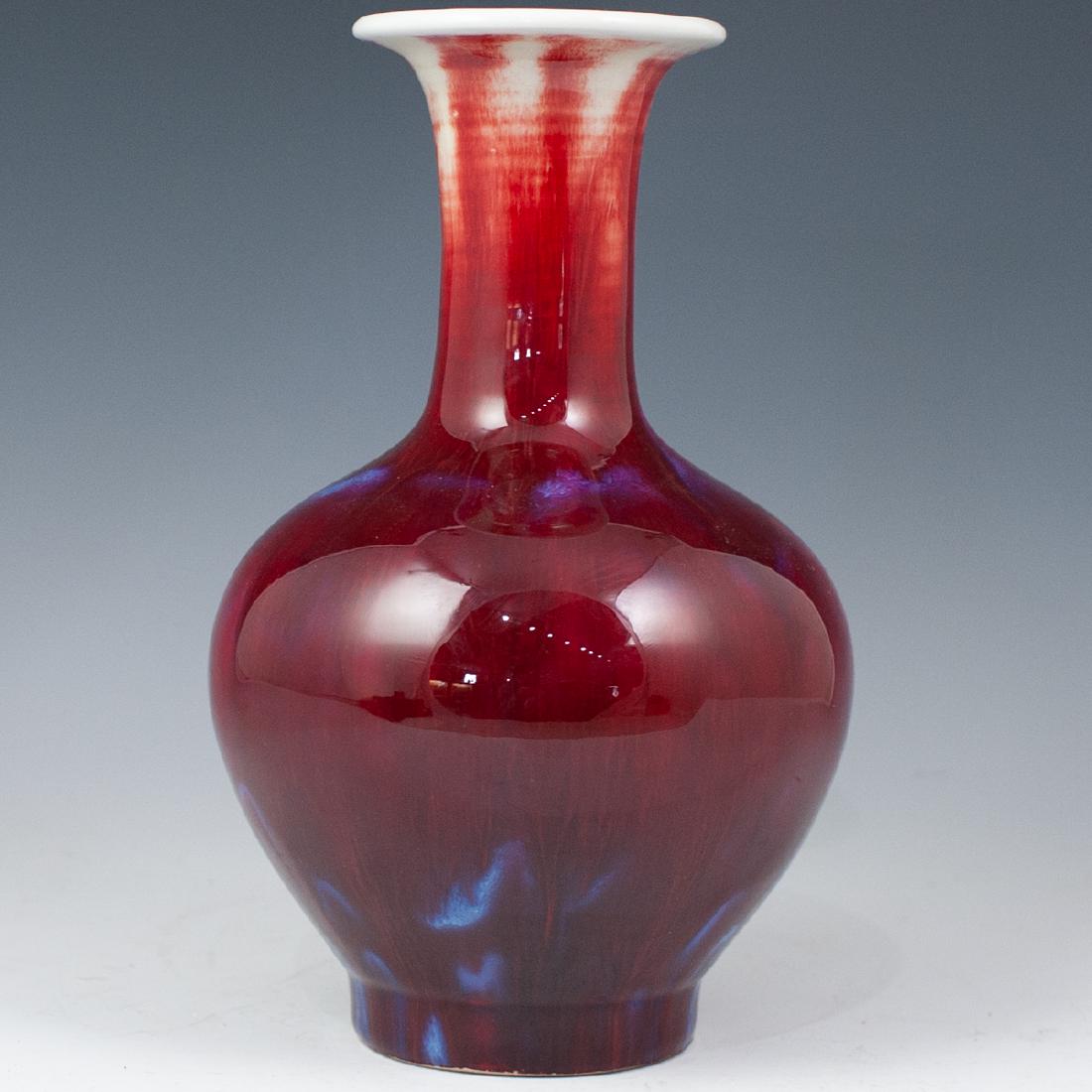 Chinese Porcelain Sand De Boeuf Vase: DESCRIPTION: Chinese porcelain vase features a bulbous base, think neck and a wide mouth opening. Embellished in a rich sang de boeuf glaze with celestial blue accents. Marked underneath with blue Chi