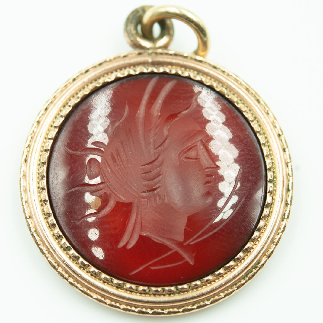 Vintage Red Carnelian Intaglio Pendant: DESCRIPTION: An Intaglio cameo pendant, features a circular carved red carnelian depicting a feminine figure, encompassed by a 14k gold frame. CIRCA: Mid 20th Ct. ORIGIN: Italy DIMENSIONS: Diameter: 1