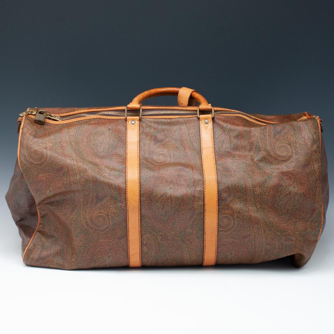 Etro Milano Paisley Duffle Bag: DESCRIPTION: An Etro Milano leather Duffle bag features an interior zipper compartment, embellished on the exterior with the "Paisley Print" stitched with tan leather straps and lining. Has some wear