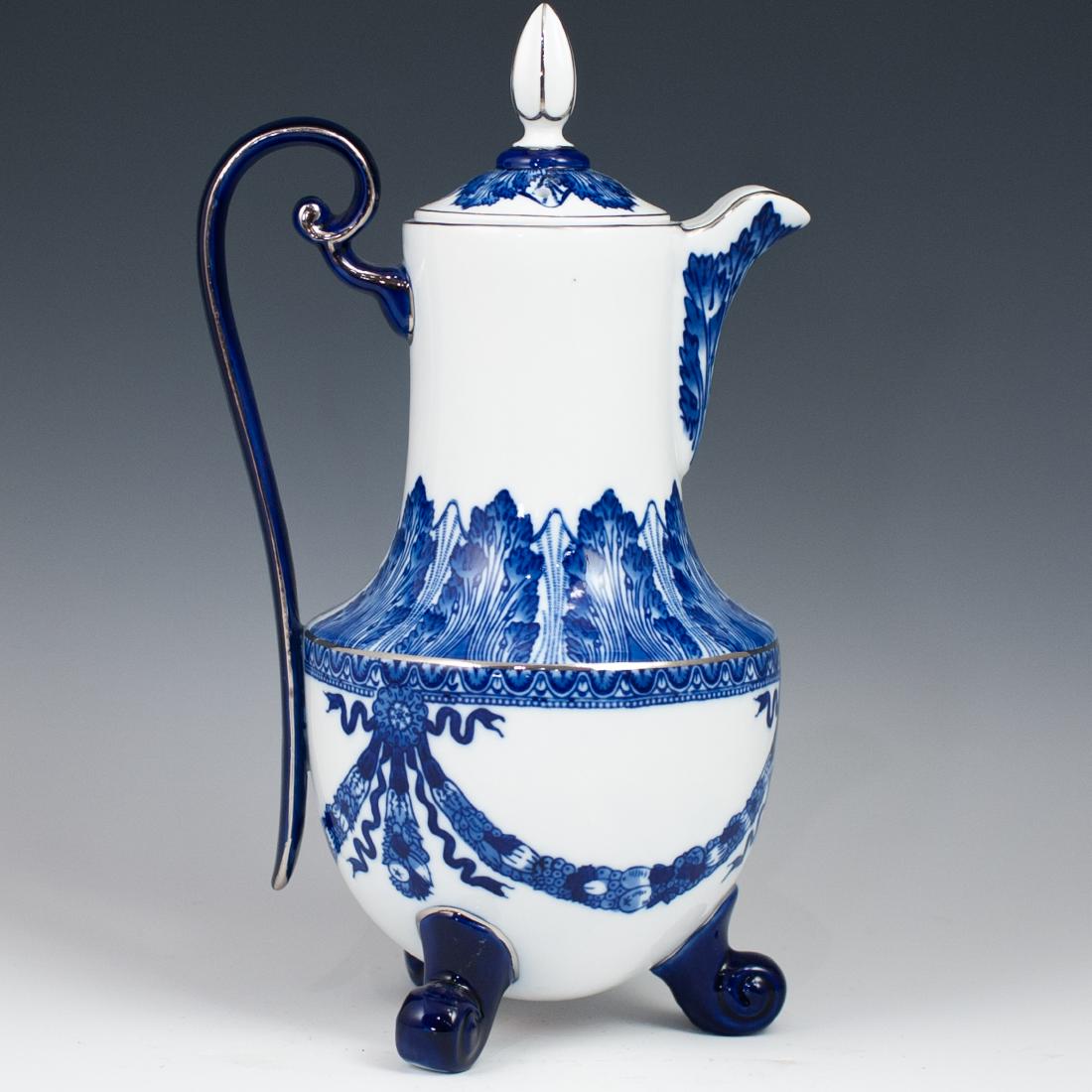 Bombay Porcelain Teapot: DESCRIPTION: A porcelain teapot decorated with blue and white patterns of floral banners, finished with silver toned trims. Stands on three cold feet and marked along the bottom "Bombay Made In China"