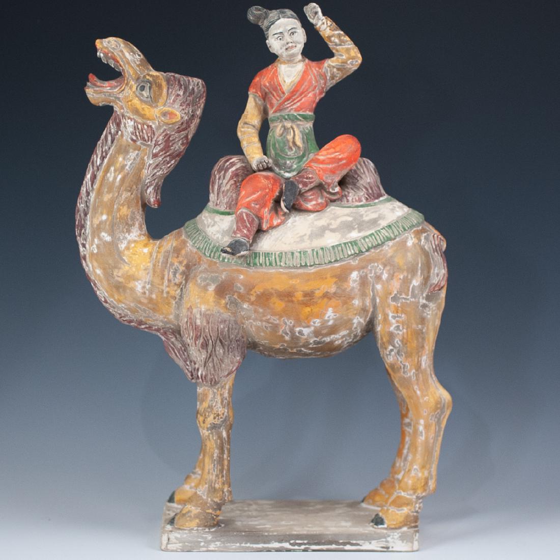 Oriental Terracotta Sculpture: DESCRIPTION: Oriental terracotta sculpture depicts a woman effortlessly riding on the back of a camel with deep carved detailing throughout. In overall yellow and beige hues with a matte finish. CIRCA