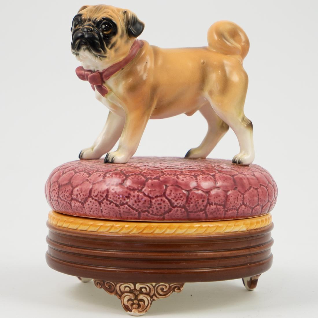 Theodora for Sigma "The Tastesetter" Porcelain Pug Box: DESCRIPTION: A Theodora for Sigma "The Tastesetter" porcelain box. Features a box standing atop the round lid that covers the base resting atop three scrolled Rococo floral motif feet. Finished in a g