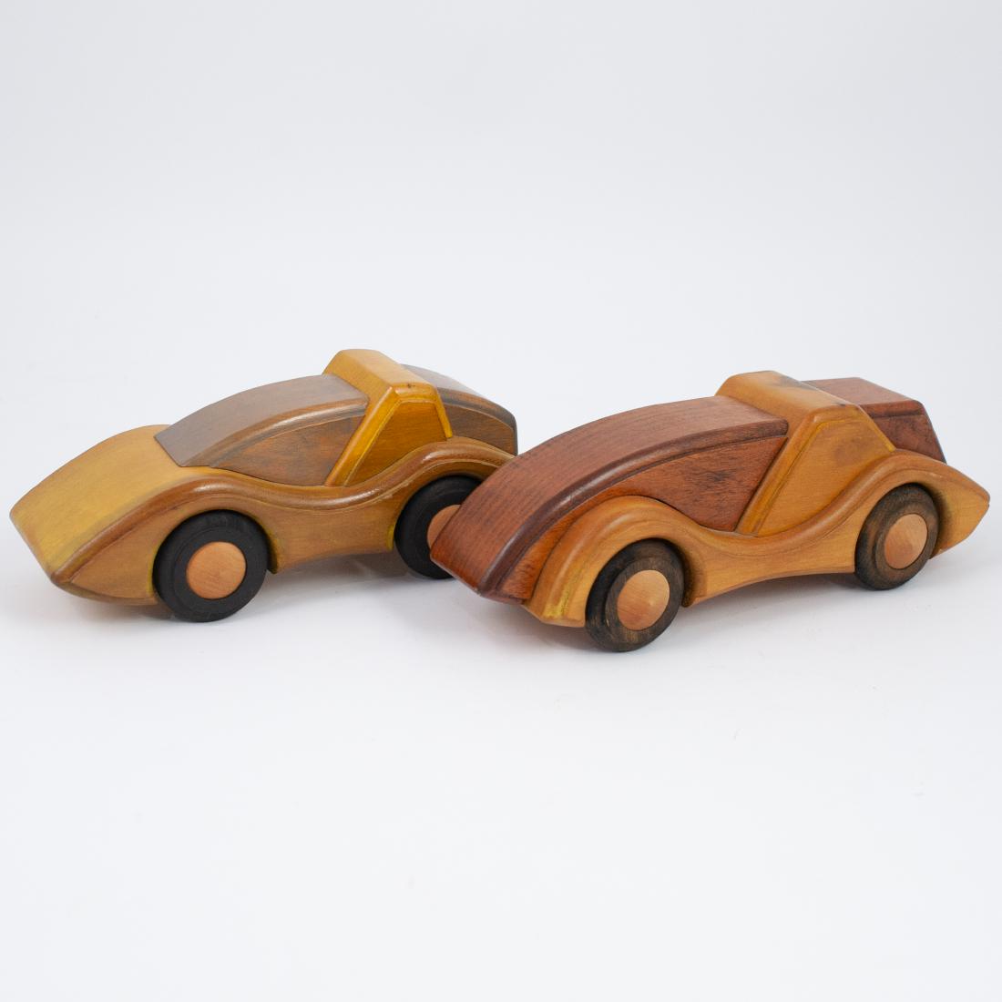 Samuel Studio Wooden Cars: DESCRIPTION: A set of two Samuel Studio carved wooden cars. Finished with rotating wooden wheels. Signed:"Sam Studio." CIRCA: Mid-Late 20th Ct. ORIGIN: USA DIMENSIONS: H:4" L:9.75" W:3.75" CONDITION: 
