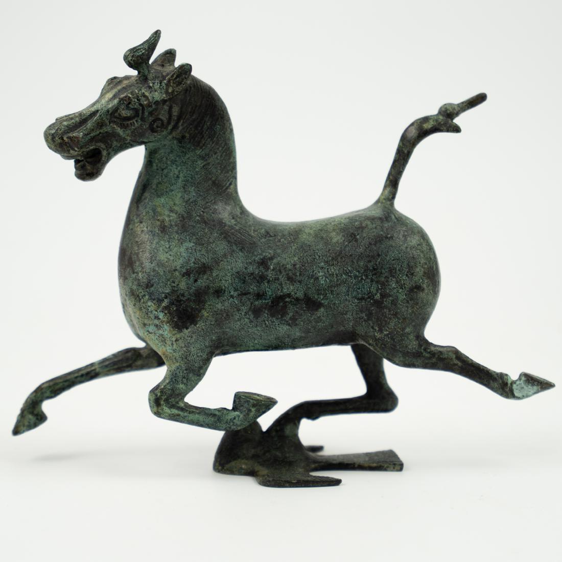 Replica Bronze "Flying Horse of Gansu": DESCRIPTION: A replice bronze sculpture of the "Flying Horse of Gansu" of the Eastern Han Period discovered in 1969. Features a galloping horse, balanced atop a board with one its hoofs. Finished with