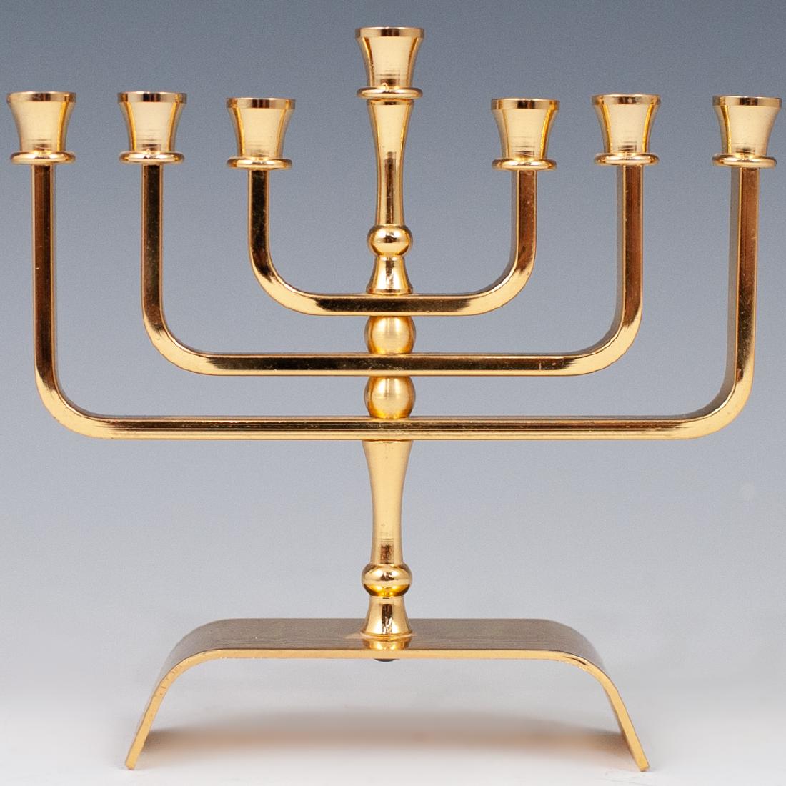 24k Gold Plated Menorah: DESCRIPTION: A 24k gold plated menorah features candle arms arching from the stem, fitted atop an elevated base. Marked underneath the base "24k Plated" CIRCA: 20th Ct. ORIGIN: Israel DIMENSIONS: H: 5