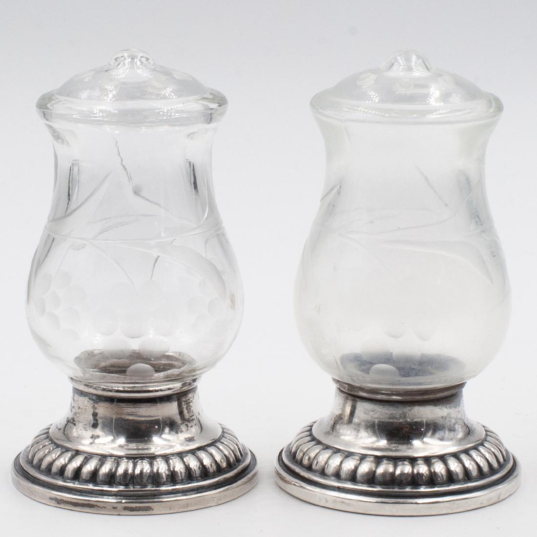 Pair Of Etched Glass & Sterling Cellars: DESCRIPTION: Pair of salt & pepper shakers features an glass cellar embellished with etched floral designs. fitted atop sterling silver bases marked along the bottom. Marked "Quaker silver & Co." And 