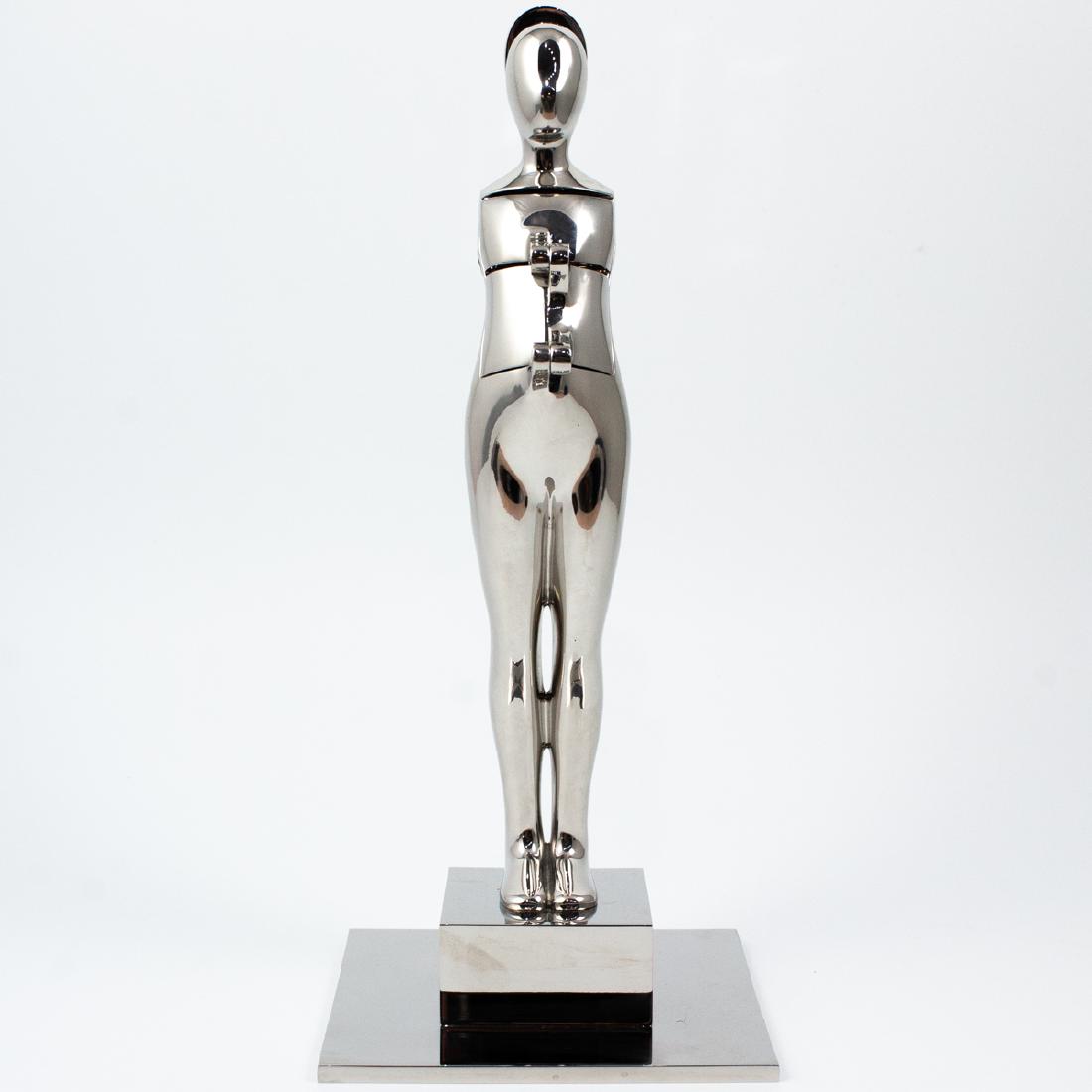 Ernest Trova (American, 1927-2007) "Flap Man": DESCRIPTION: A sculpture by American surrealist artist Ernest Trova features a stainless steel figure titled "Flap Man" crafted with mechanical appendages. The torso, back, and face swing open by hing