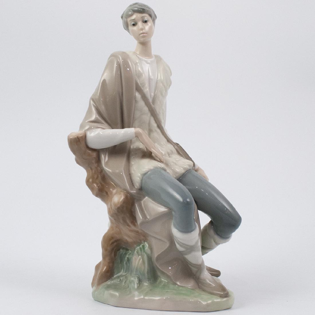 Lladro Porcelain Messenger Figurine: DESCRIPTION: A Lladro porcelain figurine. Depicts a young boy carrying a messenger satchel, seated atop a tree stomp and completed in a gloss glaze finish. Stamped along the underside "Lladro Made In 