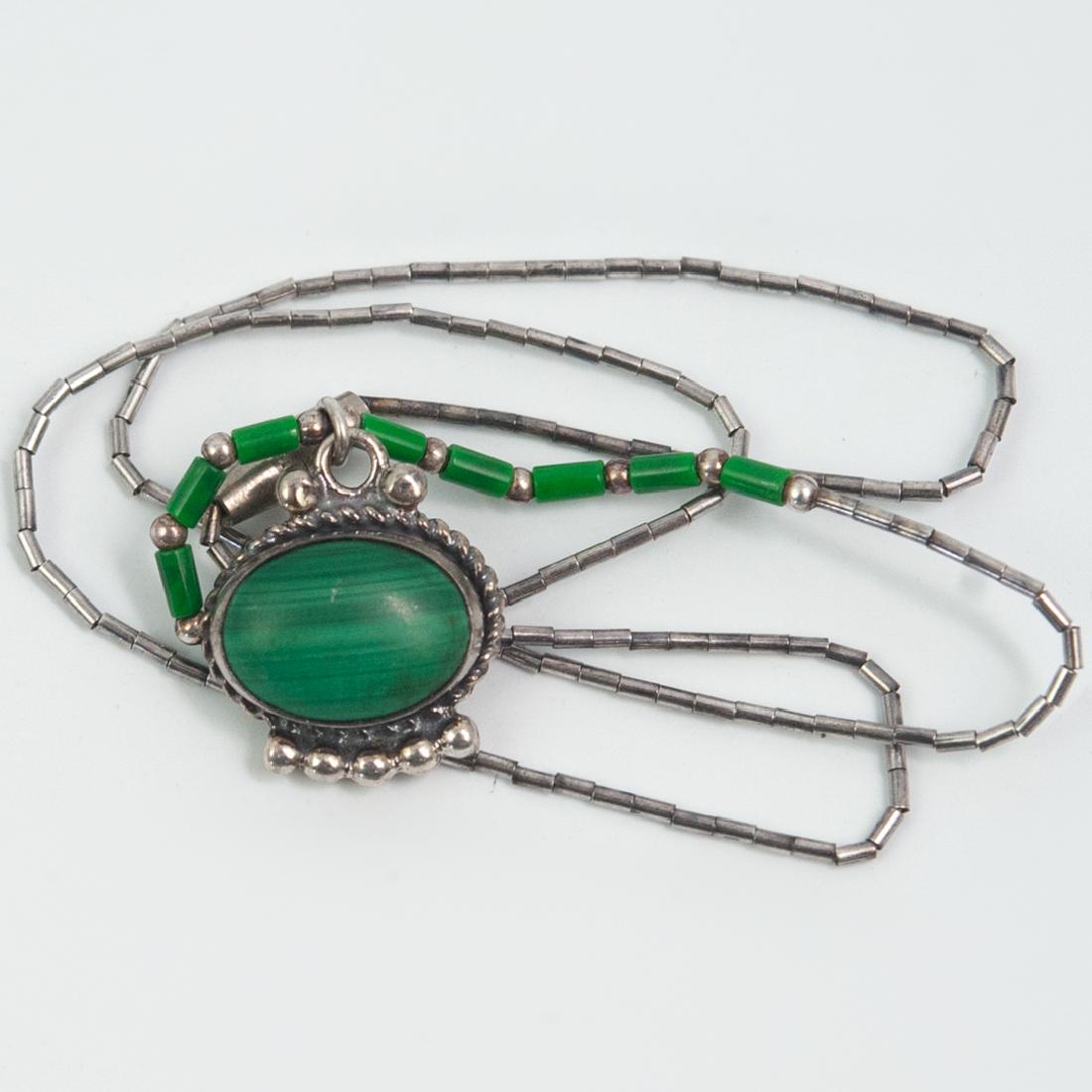 Sterling Silver and Malachite Necklace: DESCRIPTION: A Sterling silver and malachite necklace. Features silver link chain with small malachite stones fitted onto the chain, finished with a sterling silver and malachite pendant, ending with