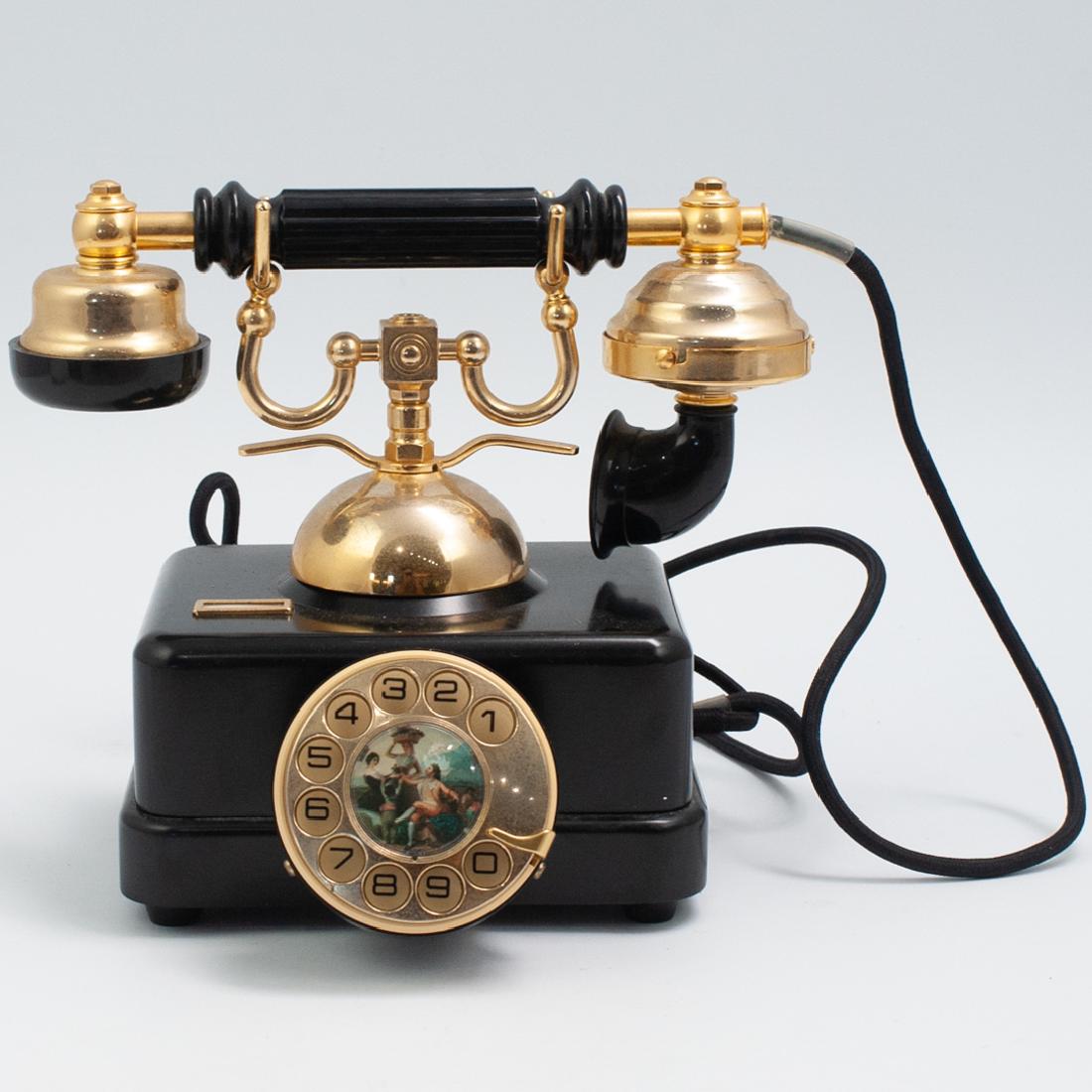 Spanish Antique Phone: DESCRIPTION: A Spanish antique phone manufactured by Elasa. Features metal black box with central numeral dial depicting an image from a Francisco Goya painting. The dial and earpiece are made from br