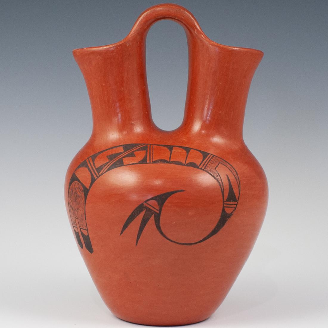 Clara Peesha Hopi Pottery Wedding Jug: DESCRIPTION: A Hopi pottery wedding jug by Clara Peesha. Features an earthy orange tone garnished with a swirled design in black along the front. The piece is designed in an overall acorn form with tw