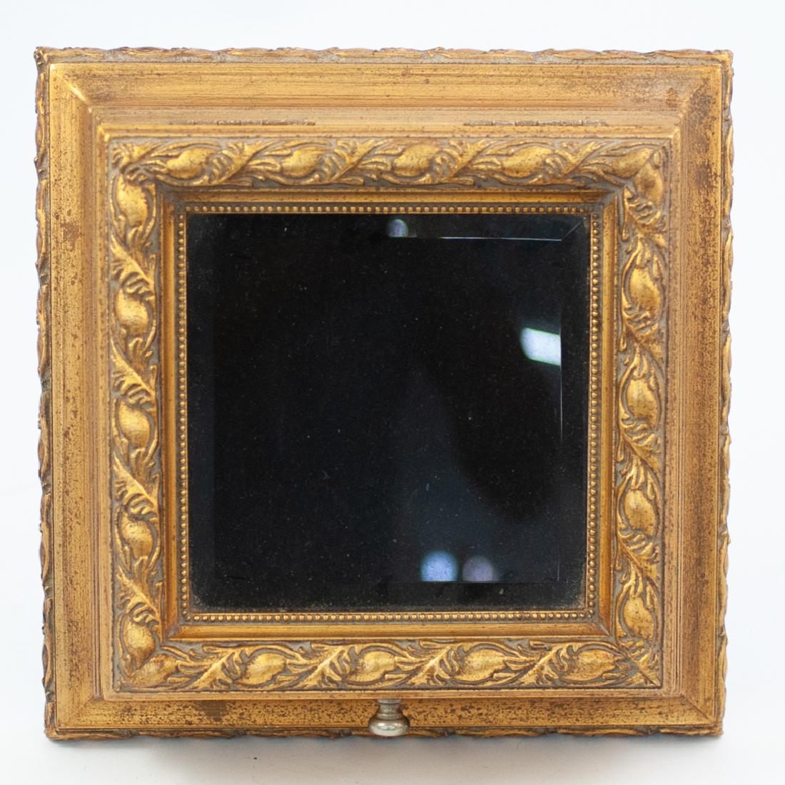 Carved Giltwood and Mirror Box: DESCRIPTION: A carved giltwood and mirror top jewelry footed box. Features carved giltwood design, with hinged top, having framed mirror glass panel top with knobs to open and reveal a black velvet li