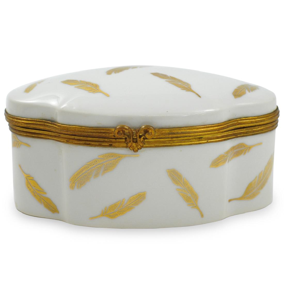 Limoges Porcelain Feather Box: DESCRIPTION: A Limoges porcelain box garnished with falling gilded feathers along the lid and body, completed with brass lining with a trident clasp, marked along the underside "Limoges France" CIRCA: