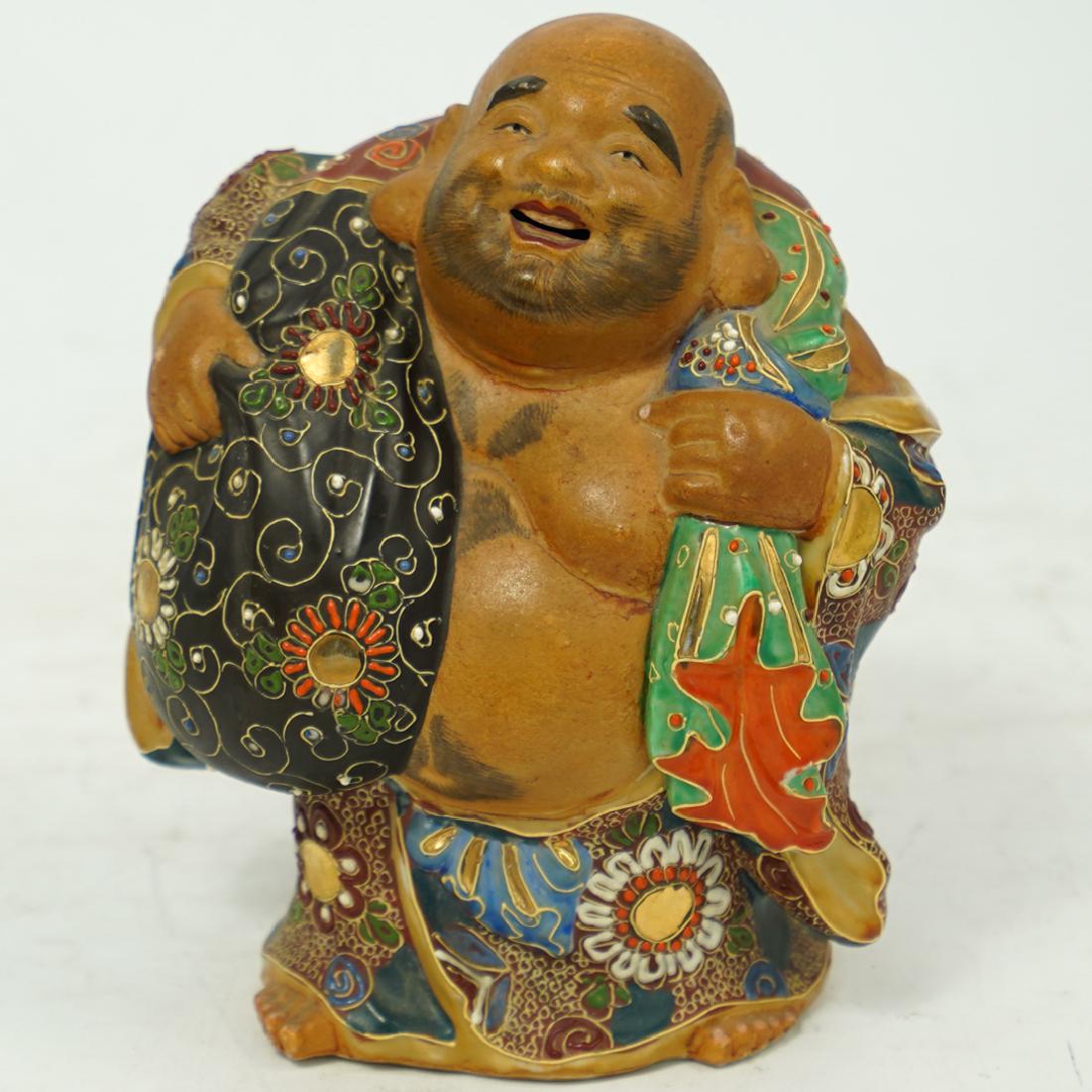 Japanese Earthenware Satsuma Buddha: DESCRIPTION: A Japanese Earthenware Satsuma Buddha. Decorated and adorned. Signed with character marks on base. CIRCA: Early 20th Century ORIGIN: Japan DIMENSIONS: H. 7" x W. 6" CONDITION: Good condit