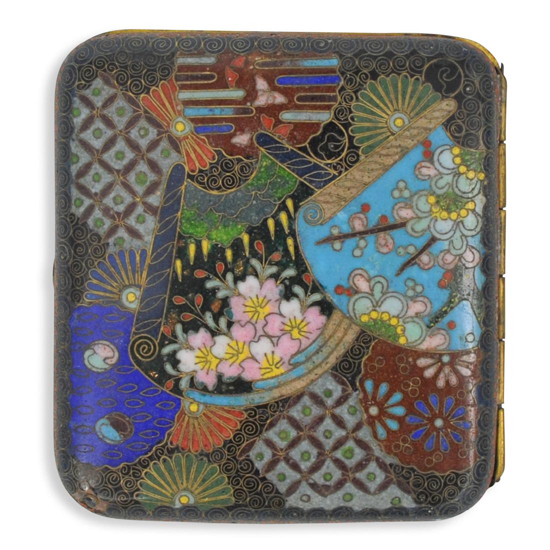 Japanese Enamel Cloisonne Case: DESCRIPTION: A Japanese cloisonne enameled cigarette case. Features elegant enameled floral motif along with diamond designs and spiraled accents along the borders. Opens to reveal two elastic straps 