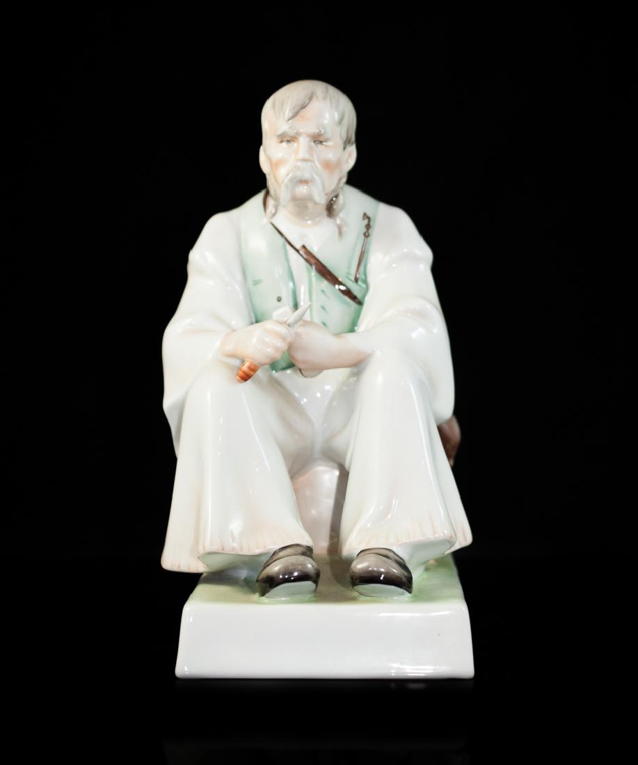 Zsolnay Woodcarver Porcelain Figurine: DESCRIPTION: Zsolnay pecs multicolored handpainted porcelain figurine features a older man carving wood. Marked on the bottom "Pecs". CIRCA: 20th Ct. ORIGIN: Hungary DIMENSIONS: H:11.5" L: 8.5" CONDIT