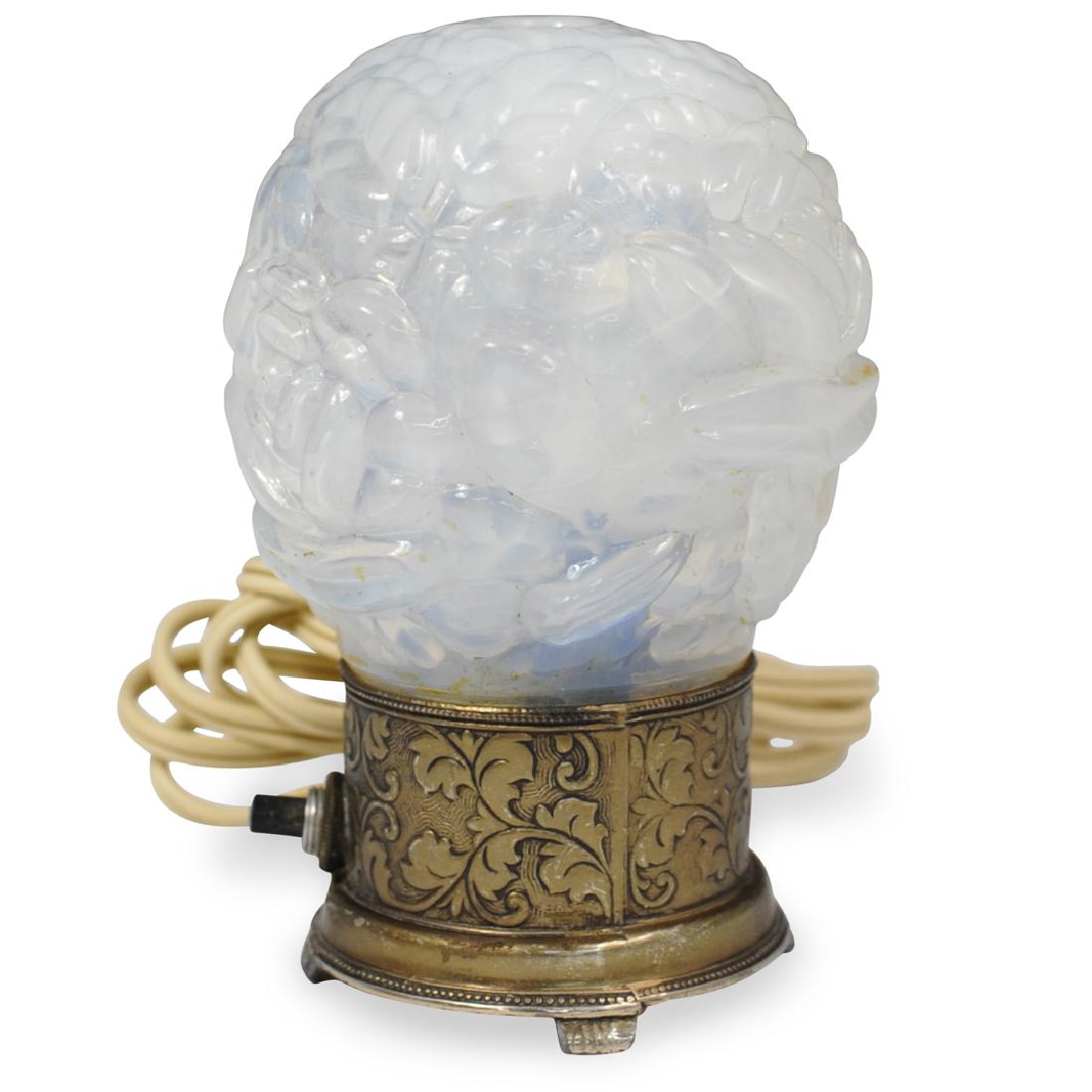 Opalescent Glass Perfume Lamp: DESCRIPTION: An Opalescent glass Perfume lamp. Features a relief carved floral motif glass shade on a decorated brass base. Electrified.Ã‚ CIRCA: 20th Century ORIGIN: Continental DIMENSIONS: H. 4.7