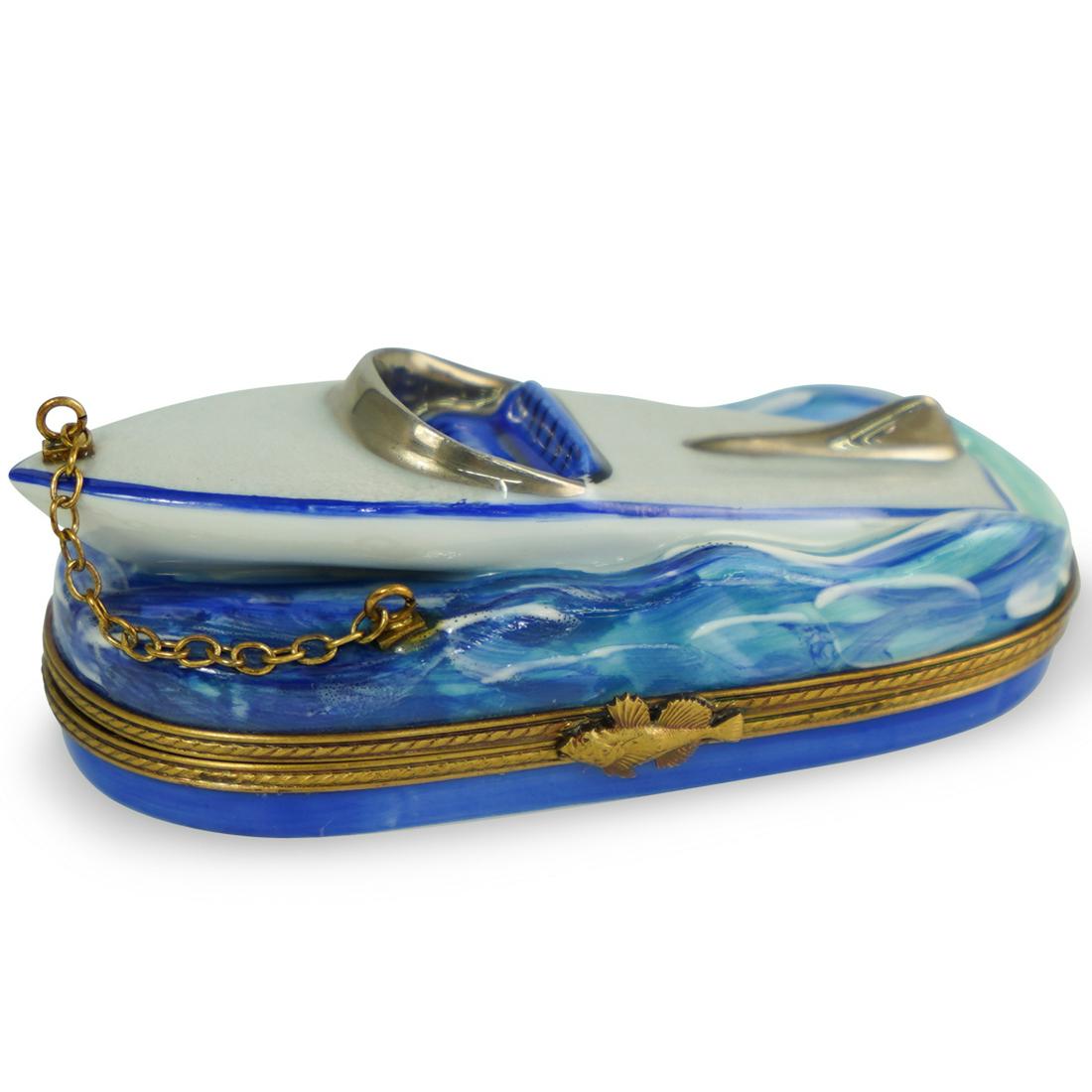 Limoges Speed Boat Trinket Box: DESCRIPTION: A La Gloriette Limoges porcelain hand-painted speed boat trinket box. Features boat motif on painted waves, interior with painted life saver, finished with gilded fish form clasp. Marked 