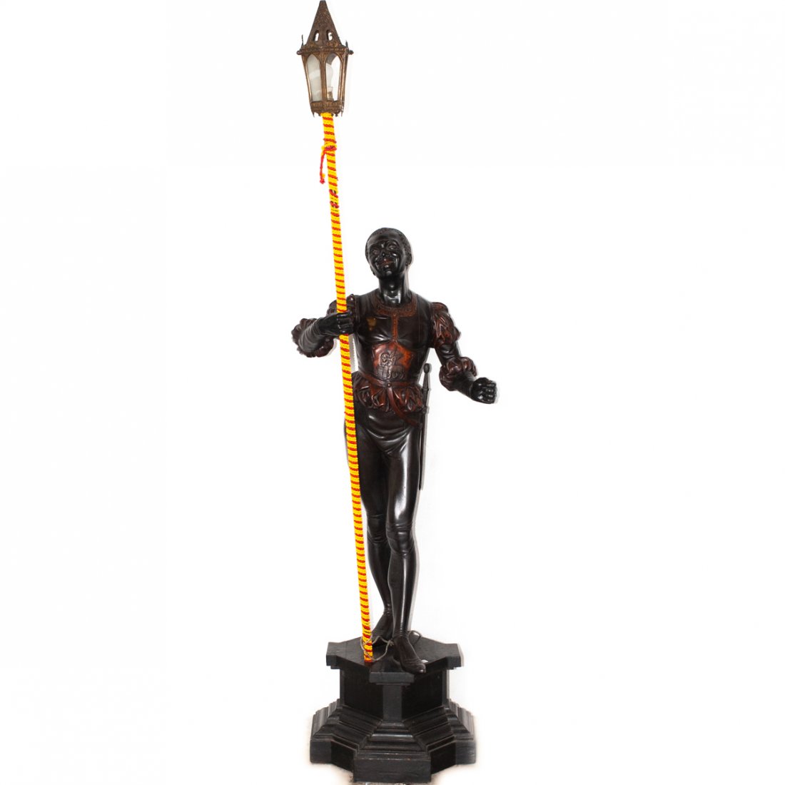Signed Italian Wooden Blackamoor Lamp: DESCRIPTION: Italian Wooden Blackamoor Statue on Wooden Base. The figure is in a stance, holding a spear with a lantern affixed to the top. Signed on the base indistinctly with artist name, additional