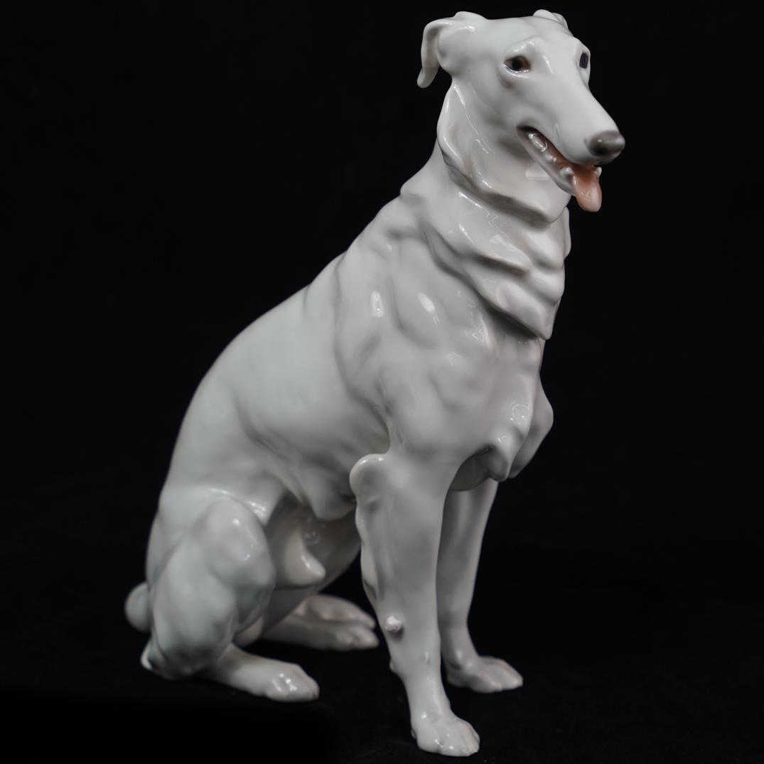 Bing and Grondahl Porcelain Dog: DESCRIPTION: A Bing & Grondahl Figurine Sitting Borzoi #1814. Designed by Lauritz Jensen. Marked and numbered on the underside. CIRCA: 20th Century ORIGIN: Germany DIMENSIONS: H. 8.5" x W. 6"Ã‚ CON